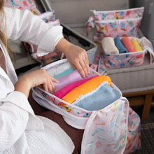 Load image into Gallery viewer, A person packing colorful clothes into a Bumkins Packing Cube 2 Pack: Boots made from waterproof fabric, with more organizers nearby.