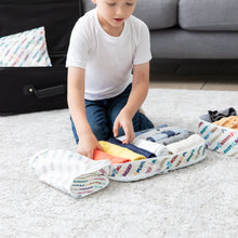 Load image into Gallery viewer, A child organizes clothes in Bumkins Packing Cube 2 Pack: Mickey & Friends Varsity, with a couch and suitcase in the background.