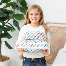 Load image into Gallery viewer, A girl smiles while she holds Bumkins Packing Cube 2 Pack: Mickey & Friends Varsity in her hands.