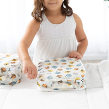 Load image into Gallery viewer, A child in a white dress zips Bumkins Packing Cube 2 Pack: Winnie + Friends on a white bed.