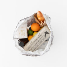 Load image into Gallery viewer, A Bumkins Packable Tote Bag: Lunar Phase holds eggs, an orange, a lime, cheese, and bread on a white backdrop.