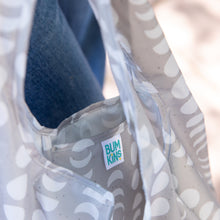 Load image into Gallery viewer, Close-up of a Bumkins Packable Tote Bag: Lunar Phase, showcasing the brand label on the interior pocket.