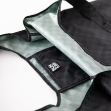 Load image into Gallery viewer, Close-up of a Bumkins Packable Tote Bag: Rich Black on a white background, with focus on the interior pocket.