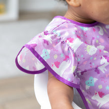 Load image into Gallery viewer, Close-up of a child wearing Bumkins Ruffle Apron Bib: Unicorns, with focus on the ruffle sleeve.