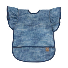 Load image into Gallery viewer, Bumkins Ruffle Apron Bib: Crushed Denim features blue denim printed waterproof fabric, ruffle sleeves, dark blue trim, and front pocket.