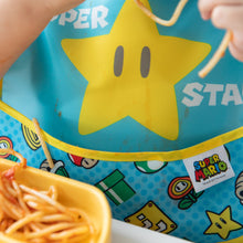 Load image into Gallery viewer, Close-up of a child wearing a sauce splattered Bumkins SuperBib® 2 Pack: Super Mario™ Expressions by a plate of spaghetti.