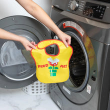 Load image into Gallery viewer, A person holds a Bumkins SuperBib® 2 Pack: Super Mario™ in front of an open front-loading washing machine.