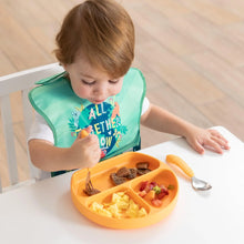 Load image into Gallery viewer, A toddler in a Bumkins SuperBib® 3 Pack: All Together Now enjoys scrambled eggs and fruit with a fork from an orange plate at a table.