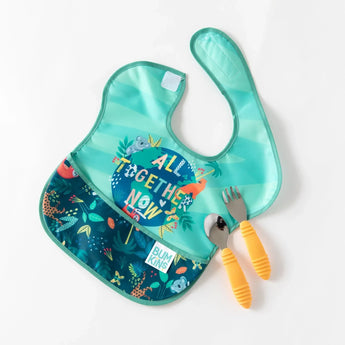 A spoon and fork with yellow handles lay partially on a Bumkins SuperBib® 3 Pack: All Together Now on a white background.