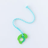 Bumkins Silicone Teether: Dinosaur lays on a white background attached to a blue silicone tether.