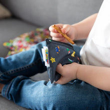 Load image into Gallery viewer, Close-up of a child enjoying a snack from a Bumkins Reusable Snack Bag, 3-Pack: Super Mario™ Power Up on a gray couch.