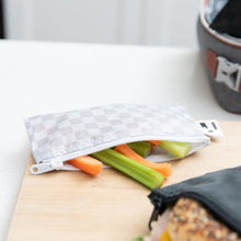 Load image into Gallery viewer, A Roamio by Bumkins Reusable Snack Bag, Small 2 Pack: Rich & Boujee holds carrot & celery sticks on a cutting board on a kitchen counter.