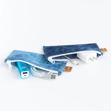 Load image into Gallery viewer, Roamio by Bumkins Reusable Snack Bag, Small 2 Pack: Denim on Denim lays open on a white background with electronics like cables inside.