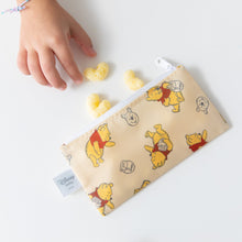 Load image into Gallery viewer, A child reaches for snacks near a Bumkins Reusable Snack Bag, Small 2 Pack: Pooh Bear and Friends on a white table.