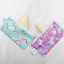Load image into Gallery viewer, Sandwich halves peek out from Bumkins Reusable Snack Bag, Small 2-Pack: Rainbows & Unicorns on a marble background.