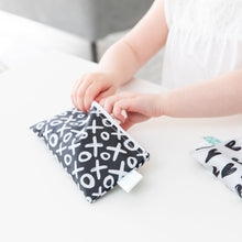 Load image into Gallery viewer, Close-up of a child reaching into a Bumkins Reusable Snack Bag, Small 2-Pack: XOXO & Hearts on a white table.
