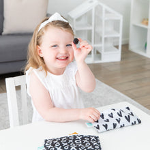 Load image into Gallery viewer, A girl in a white dress holds a blackberry at a white table with Bumkins Reusable Snack Bag, Small 2-Pack: XOXO & Hearts.