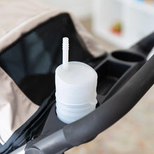 Load image into Gallery viewer, A Bumkins Silicone Straw Cup with Lid: Gray sits in the cup holder of a stroller.