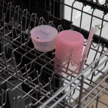Load image into Gallery viewer, Bumkins Silicone Straw Cup with Lid: Pink sits in the top rack of an open dishwasher.