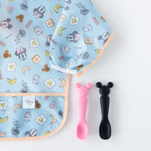 Load image into Gallery viewer, Bumkins Silicone Dipping Spoons: Minnie Mouse (Black and Pink) sit next to a blue sleeved bib with breakfast pattern on a white background.