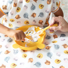 Load image into Gallery viewer, A child eats yogurt with Bumkins Silicone Dipping Spoons: Winnie the Pooh from a bear-shaped plate on a tablecloth, assisted by an adult.