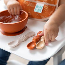 Load image into Gallery viewer, A toddler in a bib sits at a highchair, joyfully exploring self-feeding with Bumkins Silicone Dipping Spoons 3 Pack: Rocky Road.