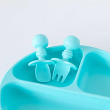 Load image into Gallery viewer, Close-up of Bumkins Silicone Chewtensils®: Blue in an empty section of a blue divided plate on a white background.