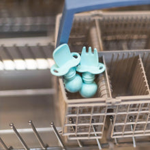 Load image into Gallery viewer, Bumkins Silicone Chewtensils®: Blue sits in the utensil compartment of an open dishwasher.