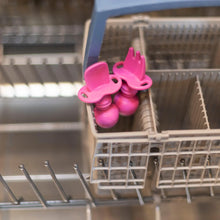 Load image into Gallery viewer, Bumkins Silicone Chewtensils®: Fuchsia sits in the utensil compartment of an open dishwasher.