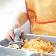 Load image into Gallery viewer, Close-up of a child's hand using a Bumkins Silicone Chewtensils®: Gray to eat spaghetti from a gray divided plate.
