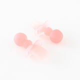 Bumkins Silicone Chewtensils®: Pink Jelly are displayed on a white background with one face-down, showcasing sensory bumps on the back.