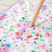 Load image into Gallery viewer, Bumkins Silicone Chewtensils®: Purple Jelly lay on top of a floral play mat next to pieces of tomato.