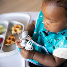 Load image into Gallery viewer, A toddler in a teal bib holds Bumkins Silicone Chewtensils®: Marble near a plate with raspberries, waffle pieces, and apple slices.