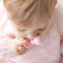 Load image into Gallery viewer, Close-up of a baby in a pink bib chewing a Bumkins Silicone Chewtensils®: Pink.