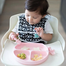 Load image into Gallery viewer, A baby in a high chair wearing a black & white bib enjoys a meal from a pink divided plate with Bumkins Silicone Chewtensils®: Pink.