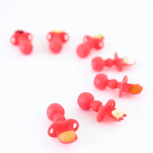 Load image into Gallery viewer, Seven Bumkins Silicone Chewtensils®: Red are arranged in a half-circle on a white background, holding toddler-portioned bites of food.