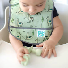 Load image into Gallery viewer, A baby in a high chair wearing a green bib plays with Bumkins Silicone Chewtensils®: Sage on the tray.