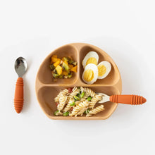 Load image into Gallery viewer, A toddler plate has sliced fruit, halved eggs, and veggie pasta, with Bumkins Spoon + Fork: Clay on a white background.