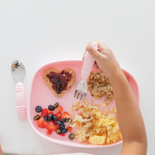 Load image into Gallery viewer, A child's hand holds a fork over a Bumkins Silicone Grip Tray: Pink with heart-shaped toast, fruit, and hash browns on a white table.