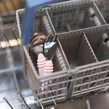 Load image into Gallery viewer, Bumkins Spoon + Fork: Pink sits in the utensil compartment of an open dishwasher.