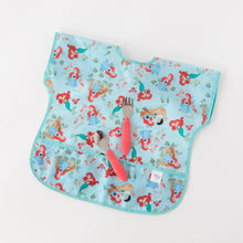 Load image into Gallery viewer, Bumkins Spoon + Fork: Red rests atop a blue mermaid patterned waterproof bib on a white background.
