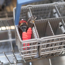 Load image into Gallery viewer, Bumkins Spoon + Fork set in red sits in the dishwashers gray basket, perfect for toddler self-feeding.