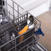 Load image into Gallery viewer, Bumkins Spoon + Fork: Tangerine sits in the utensil compartment of an open dishwasher.