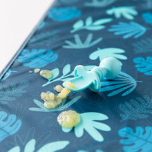 Load image into Gallery viewer, Close-up of a blue baby spoon and applesauce on top of Bumkins Splat Mat: Blue Tropic on a white background.