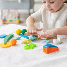 Load image into Gallery viewer, A child joyfully molds colorful clay on a Bumkins Splat Mat: Wander at a table.