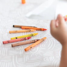 Load image into Gallery viewer, Close-up of a child's hand reaching for crayons on a Bumkins Splat Mat: Wander.