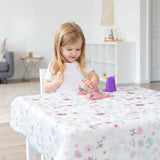 A blonde girl plays with pink kinetic sand on a Bumkins Splat Mat: Floral in a bright living room.