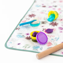 Load image into Gallery viewer, Close-up of colorful clay and toys on top of Bumkins Splat Mat: Floral on a white background.