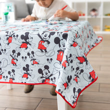 Load image into Gallery viewer, A child paints on paper at a table covered by Bumkins Splat Mat: Mickey Mouse.