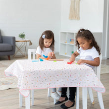 Load image into Gallery viewer, Two girls play with clay at a table covered by Bumkins Splat Mat: Princess Magic for easy cleaning.